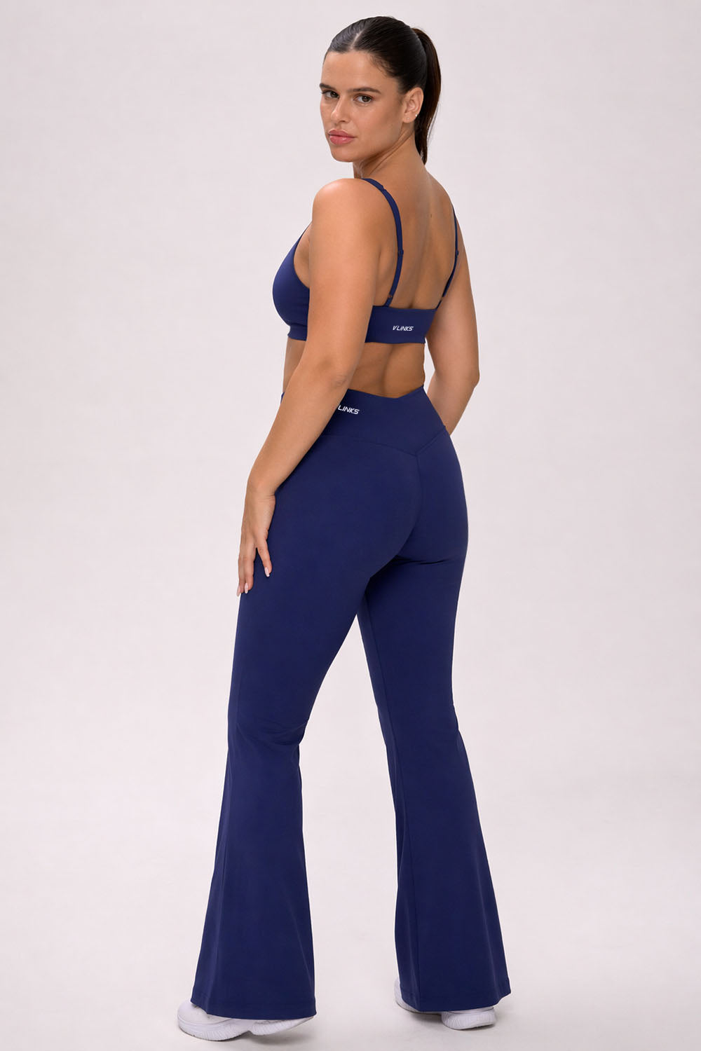 טייץ נשים מתרחב בגזרת V עם כיווצים מחטבים ובטנה כפולה – בד FLOW נושם ונמתח, זמין בגזרות Regular ו-Tall מבית VLIKS