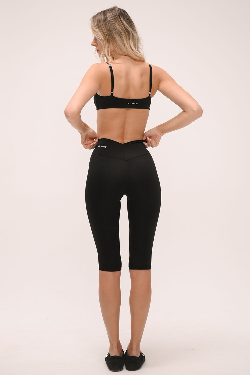 טייץ קאפרי מחטב לנשים בגזרת וי עם מותן גבוהה ומראה ספורט שיק.